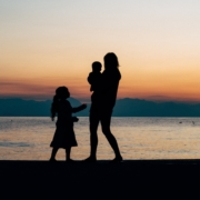 mother with adopted child looking at pink sunset
