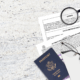 Documents for name change and a U.S. passport on a desk with glasses, pen, and magnifying glass