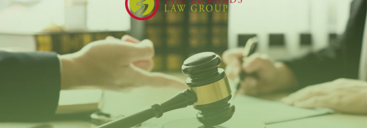Two lawyers talking at a desk with Edwards Law Group logo above