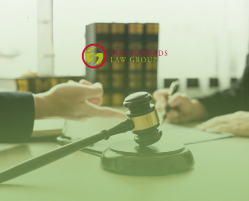Two lawyers talking at a desk with Edwards Law Group logo above